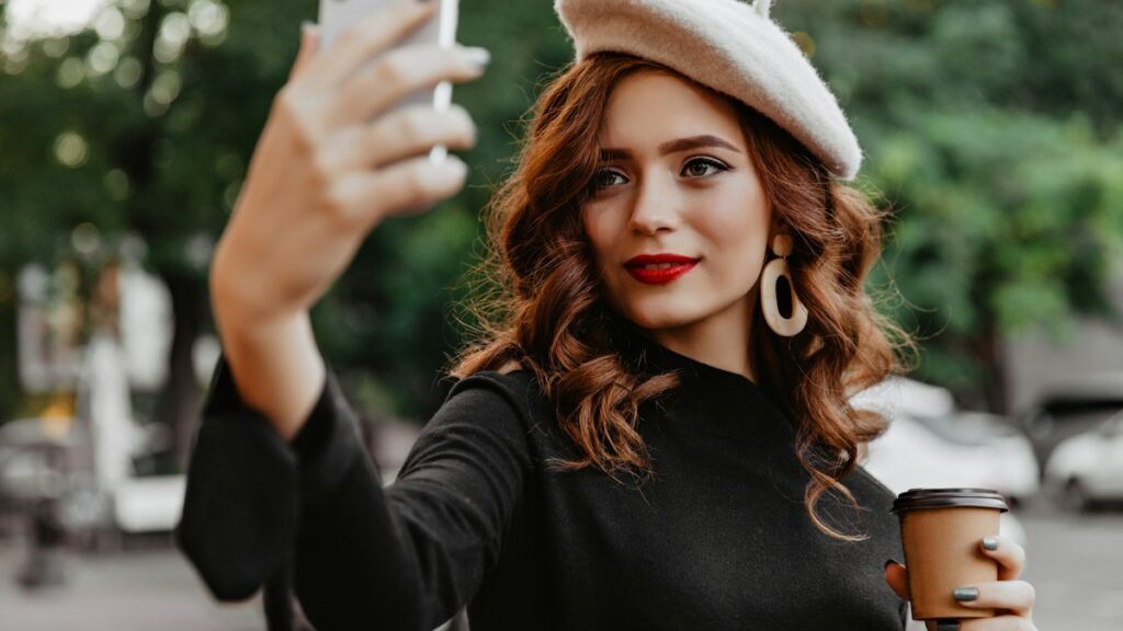High Data SIM Only Plans for Content Creators Who Post on the Go Woman in a beret taking a selfie with a coffee in hand