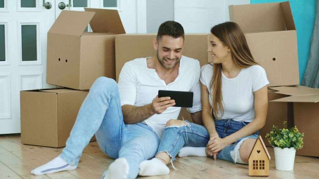 One Month Rolling SIM Only Contracts From 6GB to Unlimited Data Couple sitting among moving boxes looking at a tablet