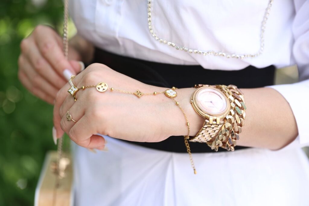 Woman wearing a gold watch with layered gold bracelets